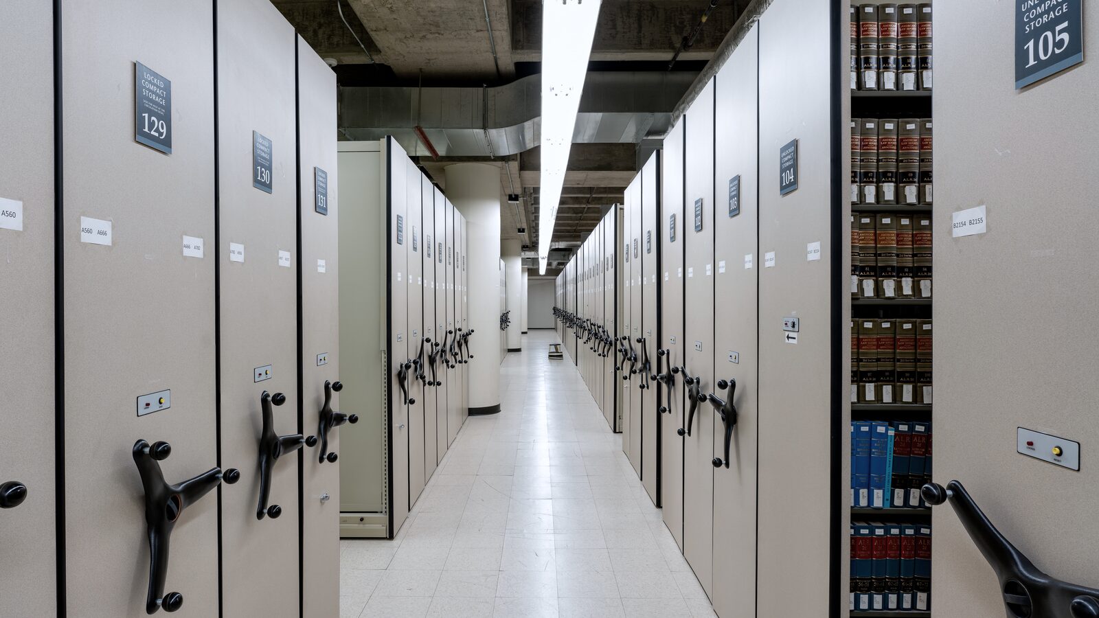 Compact archive shelving with a central aisle in perspective