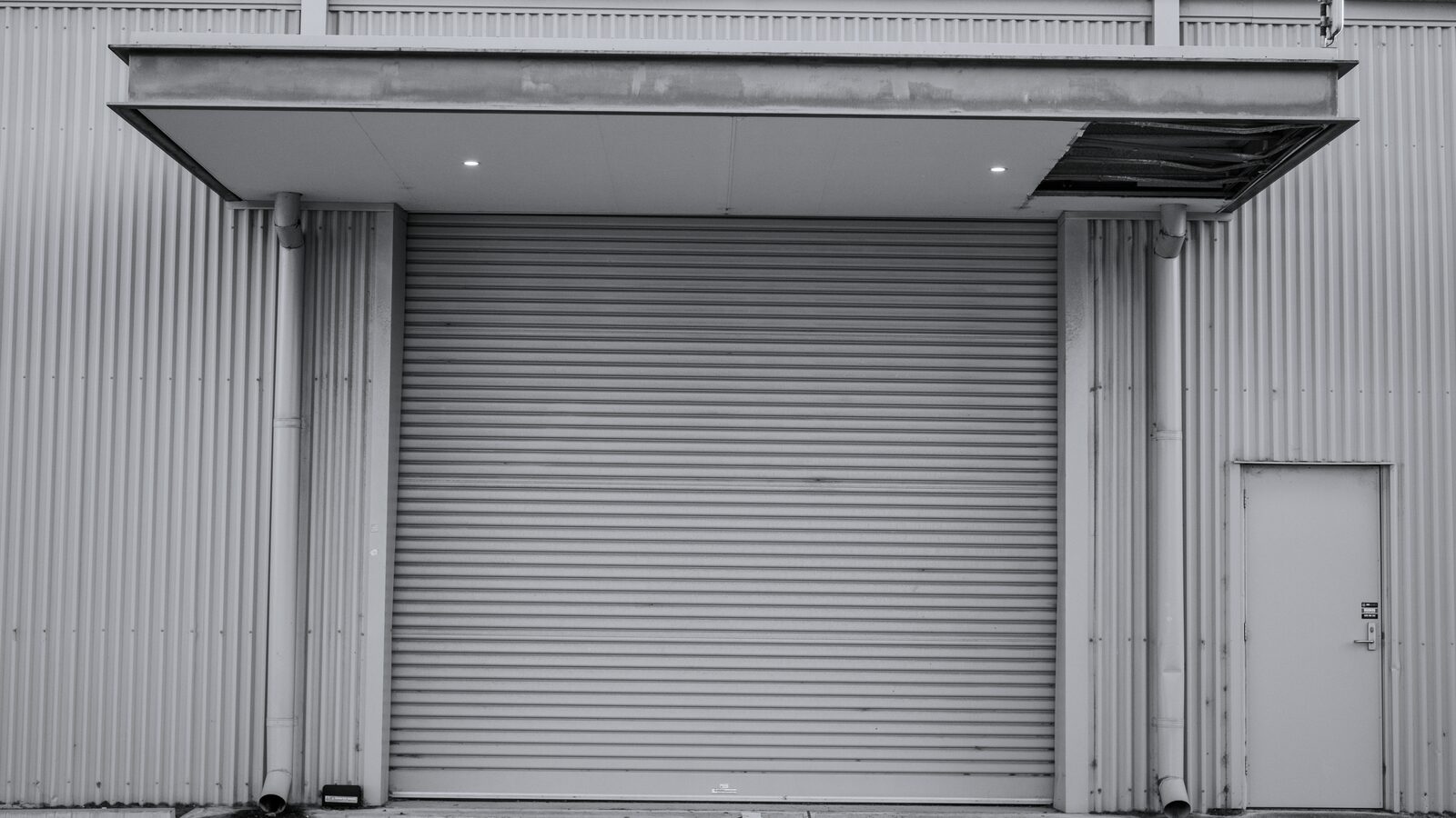 Closed roll-up service door in a corrugated metal facade